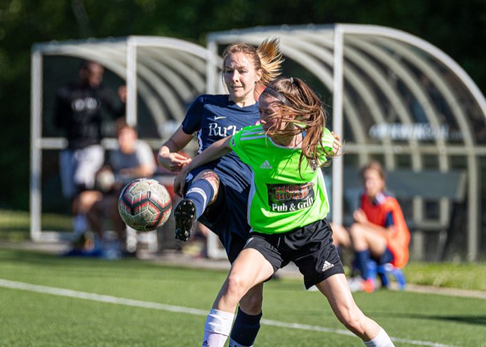OAKVILLE, ON, Jun. 23, 2019: Players battle for the ball during a League1 Ontario women's soccer game between the Oakville Blue Devils and DeRo United.