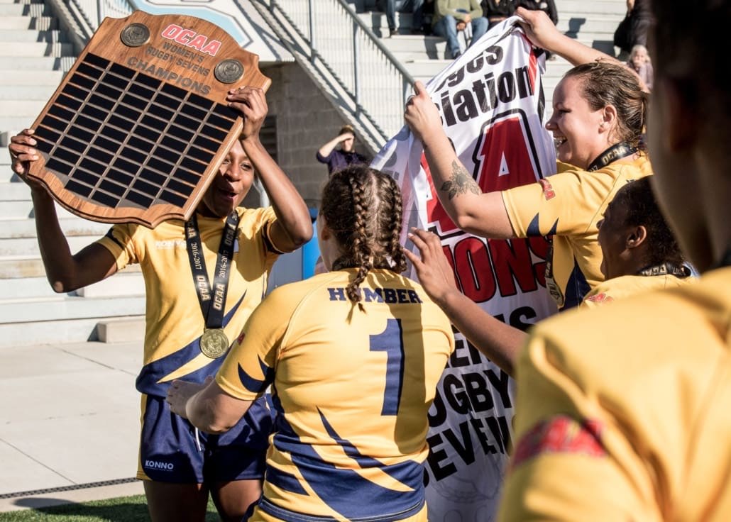 OAKVILLE, ON - Nov. 5, 2016: Christina Branch is surrounded by her Humber teammates as they celebrate winning the inaugural OCAA Women's Rugby Sevens Championship.