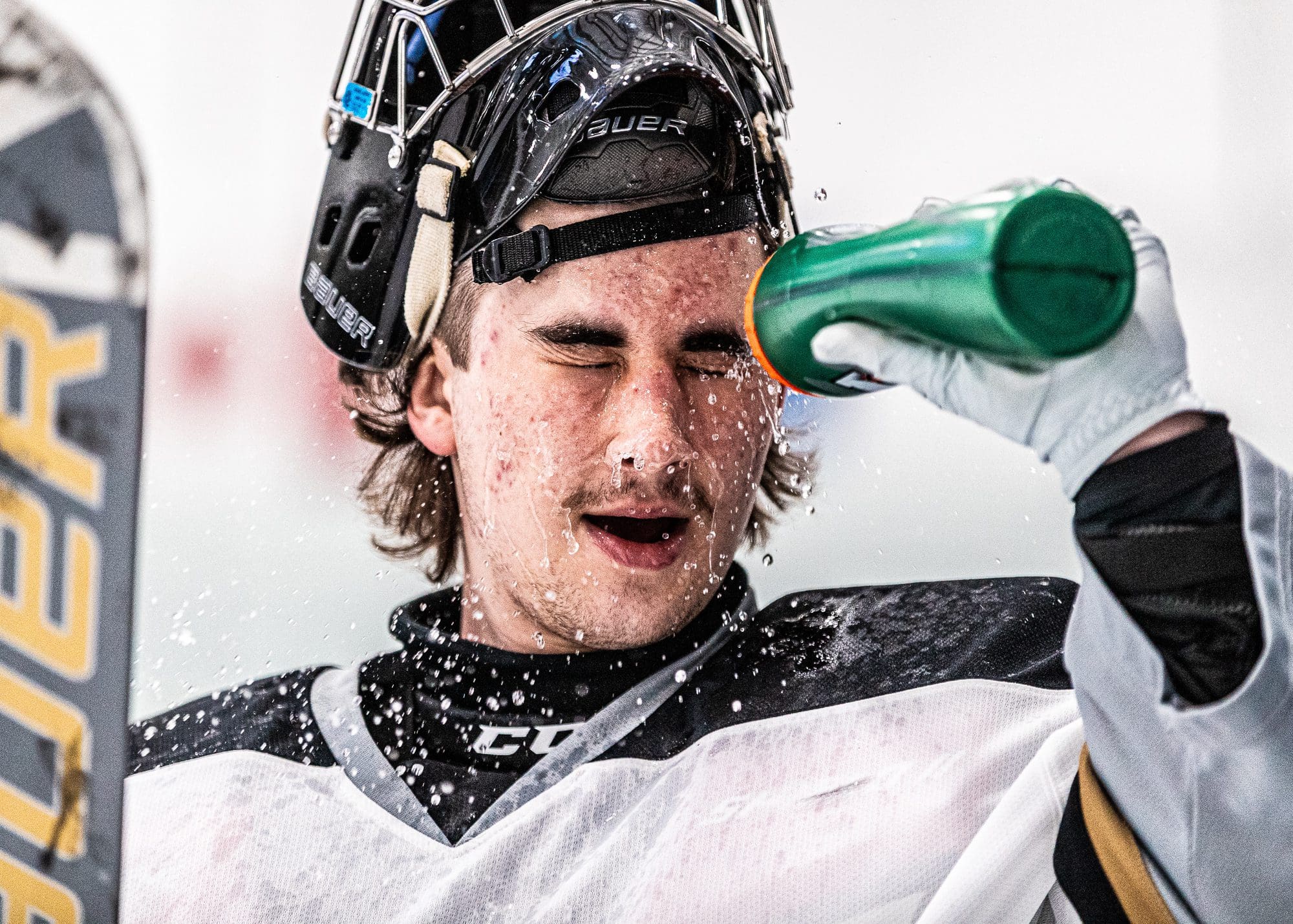 OAKVILLE, ON – NOV. 22, 2023: Milton Menace goalkeeper sprays himself with water before the start of the first period at Sixteen Mile Sports Complex. OAKVILLE, ON – NOV. 22, 2023: Milton Menace goalkeeper sprays himself with water before the start of the first period against the Oakville Blades.