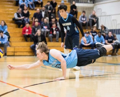 OAKVILLE, ON - NOV. 18, 2017: Liam Butchereit of the Sheridan Bruins dives for the ball in an OCAA men's volleyball game against the Humber Hawks.