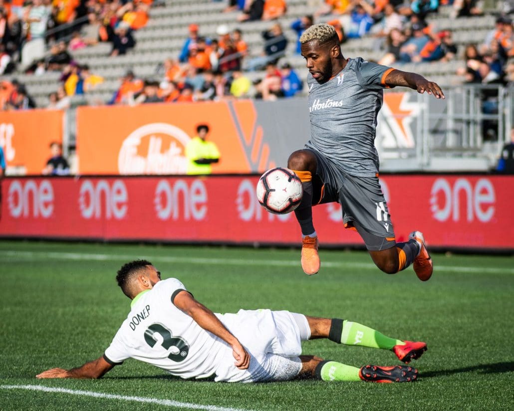 HAMILTON, ON - OCT. 6, 2019: Christopher Nanco of Forge FC jumps over Morey Doner of York9 FC in Canadian Premier League action.
